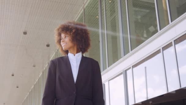 Улыбающаяся деловая женщина, выходящая за пределы офиса — стоковое видео