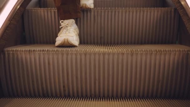 Młoda kobieta wchodzi na schodach ruchomych, aby podróżować w dół — Wideo stockowe