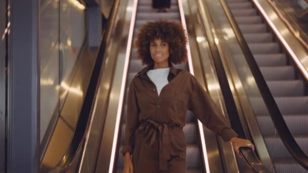 Young Woman In Brown With Afro Hair Stepping Off Escalator — Stock Video