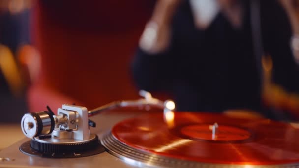 Женщина слушает Red Vinyl Record Playing on Record Player — стоковое видео
