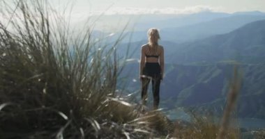 La Concha 'nın dramatik manzarasına bakan genç sarışın kadın.