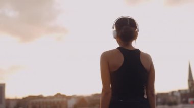 Spor Giyim 'deki kadın koşudan sonra şehre bakıyor.