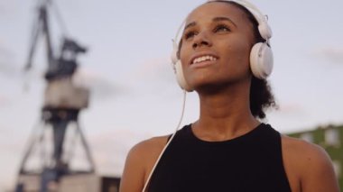 Spor Giyim 'deki kadın gün doğumuna bakıyor.