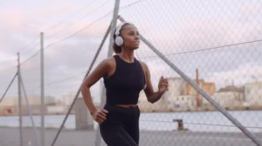 Spor Giyim ve Kulaklık Giyen Genç Kadın Limanda Koşu Yapıyor