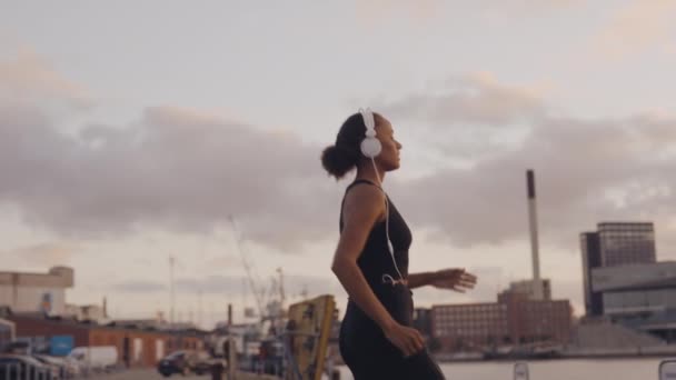 Mujer en ropa deportiva corriendo para mirar el amanecer en el puerto — Vídeos de Stock