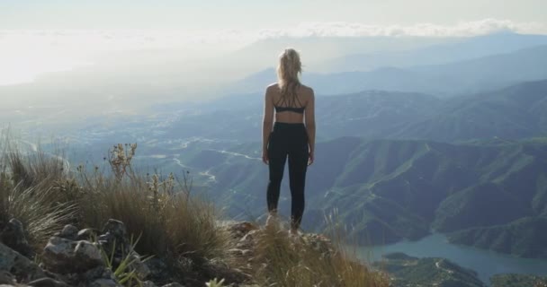 Молода блондинка, що дивиться на драматичний ландшафт Ла - Конча — стокове відео
