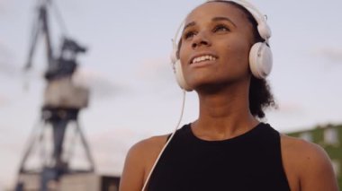 Spor Giyim 'deki kadın gün doğumuna bakıyor.