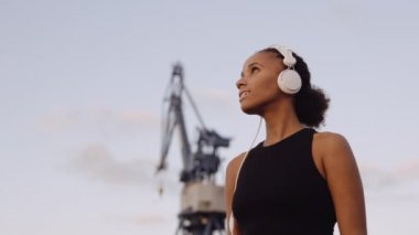 Spor Giyim 'deki kadın gün doğumuna bakıyor.