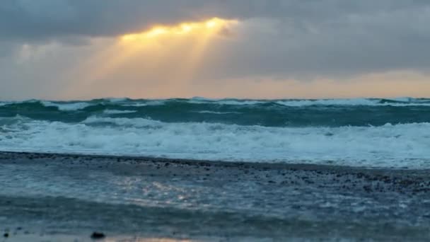 Promienie słońca świecące nad falami oceanicznymi o zachodzie słońca — Wideo stockowe