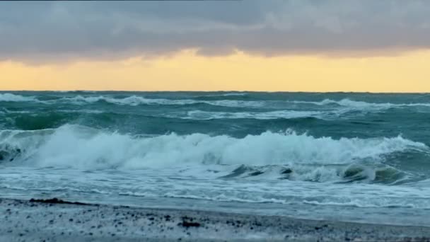曇り空から輝く夕日とビーチに圧延波 — ストック動画