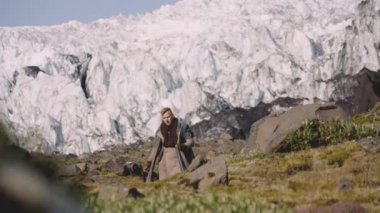 Buzulun yanındaki Rocky Hill 'de gitar çantası taşıyan gezgin.