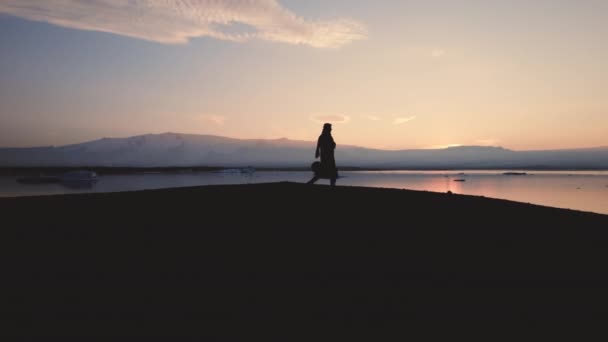Silueta del hombre caminando a través del paisaje islandés — Vídeos de Stock