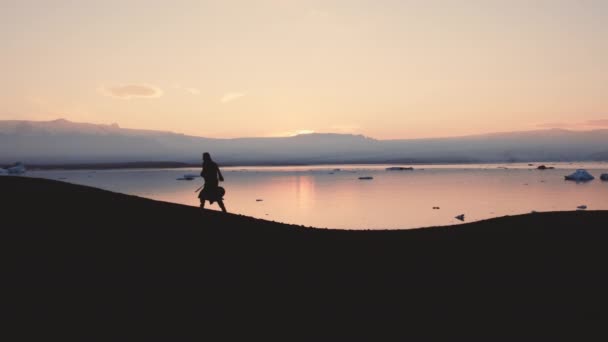 Silueta del hombre caminando a través del paisaje islandés — Vídeos de Stock