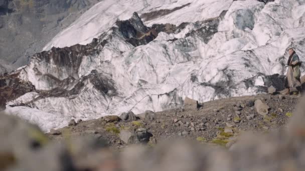 Cestovatel nesoucí pouzdro na kytaru na Rocky Hill vedle ledovce — Stock video