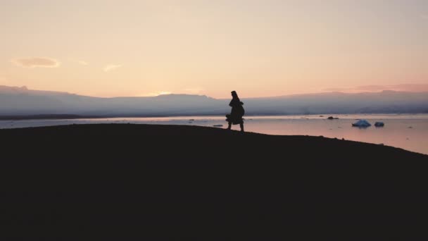 Silueta del hombre caminando a través del paisaje islandés — Vídeo de stock