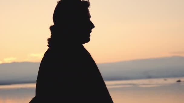 Man in silhouet wandelen door koud zonsondergang landschap — Stockvideo