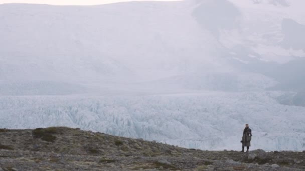 Muž stojící vedle ledovce v islandské krajině — Stock video