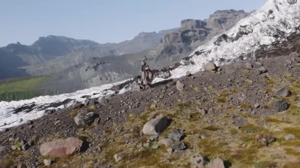 Wandernder Mann wandert felsigen Abhang hinunter — Stockvideo