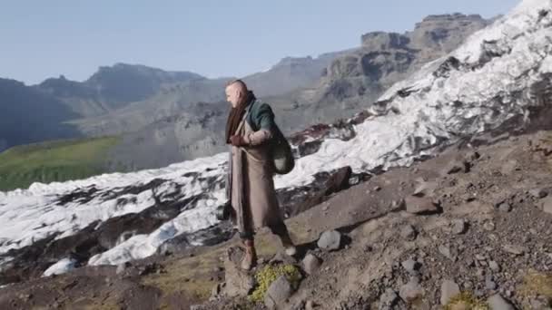 Hombre viajero de pie en Rocky Hillside By Glacier — Vídeo de stock