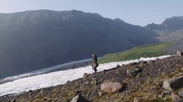 Viaggiare l'uomo Escursionismo giù Rocky Hillside By Glacier — Video Stock