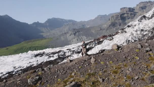 Reizende man wandelen naar beneden Rocky Hillside door gletsjer — Stockvideo