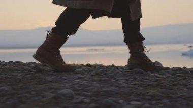 Gün batımında İzlanda 'da Yürüyen Çizmeli Adam