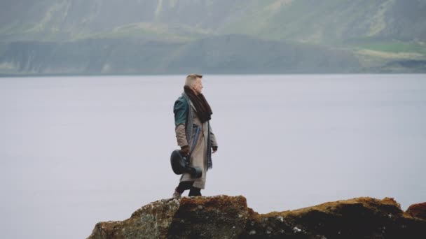 Lone Traveller Standing On Rocks And Looking Out Over Lake — Stock video