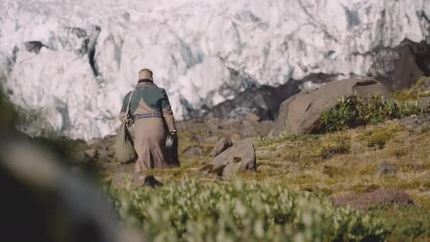 Viajero llevando estuche de guitarra en Rocky Hill junto al glaciar — Vídeo de stock