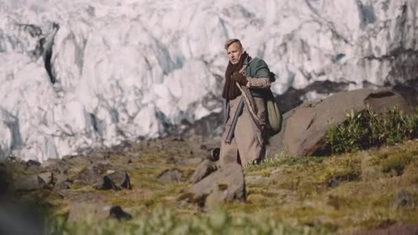 Reiziger draagt gitaar geval op Rocky Hill naast gletsjer — Stockvideo