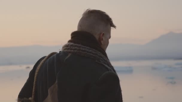 Resande man vandrar i isländskt landskap vid solnedgången — Stockvideo
