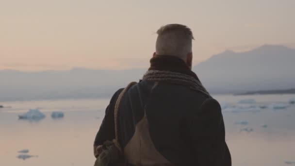 Hombre viajero caminando en el paisaje islandés al atardecer — Vídeos de Stock