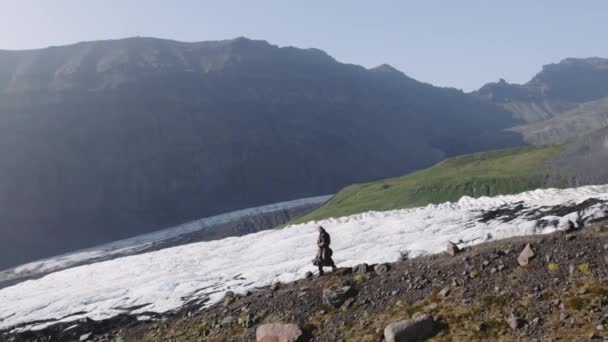 Gitar çantasıyla dağda yürüyen bir yürüyüşçü. — Stok video