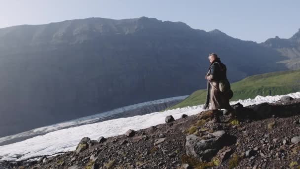 Wandelaar wandelen langs Mountainside met gitaar geval — Stockvideo