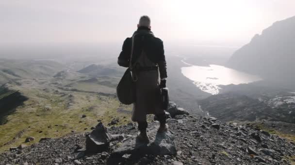 Alleinreisender blickt hinunter ins sonnenbeschienene Tal — Stockvideo