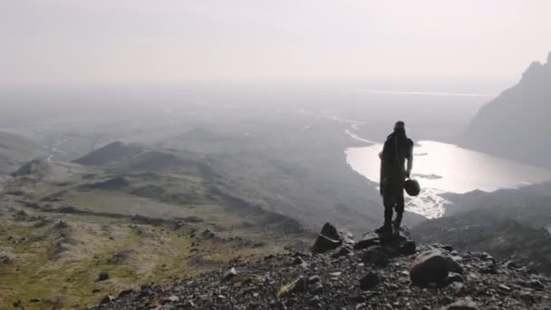 Drone Over Lone Traveller kijkt naar beneden in Sunlit Valley — Stockvideo