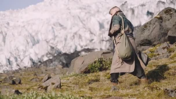Viajero llevando estuche de guitarra en Rocky Hill junto al glaciar — Vídeo de stock