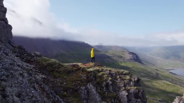 Drone vlucht van de mens staande op bergtop — Stockvideo