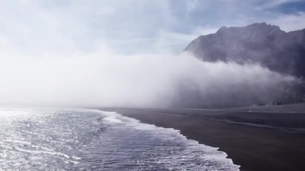 霧の下で波と黒の海岸線のドローン飛行 — ストック動画
