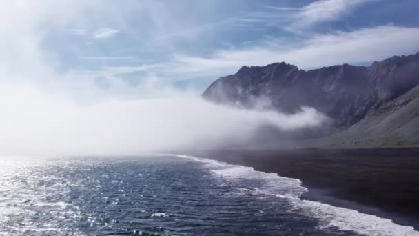 Drone vlucht van surfen en zwarte kustlijn onder mist — Stockvideo
