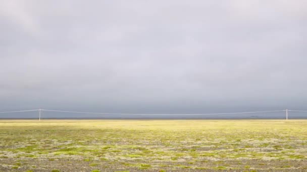 Karge Landschaft mit Masten unter wolkenverhangenem Himmel — Stockvideo