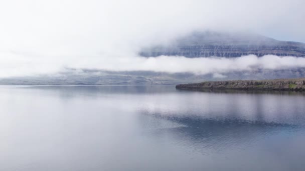 Drohnenflug über den See mit niedrigen Wolken und Bergen — Stockvideo