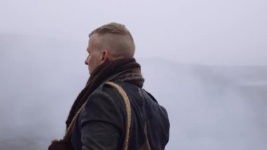 Greatcoat 'lu Adam Puslu ve Rocky Manzaralı Duruyor