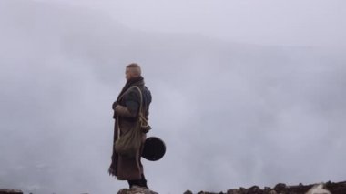 Greatcoat 'lu Adam Puslu ve Rocky Manzaralı Duruyor
