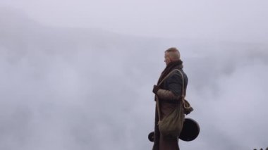Greatcoat 'lu Adam Puslu ve Rocky Manzaralı Duruyor