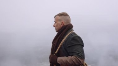 Greatcoat 'lu Adam Puslu ve Rocky Manzaralı Duruyor