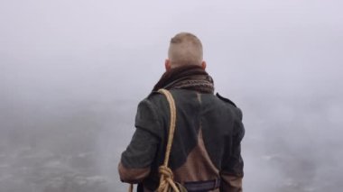 Greatcoat 'lu Adam Puslu ve Rocky Manzaralı Duruyor