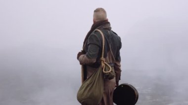Greatcoat 'lu Adam Puslu ve Rocky Manzaralı Duruyor