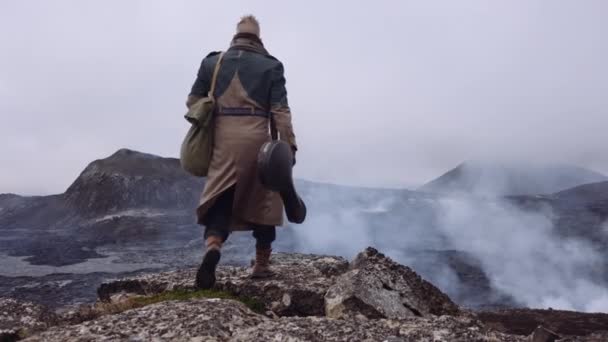 Reisender Mann trägt Gitarrenkoffer und geht über neblige Felsen — Stockvideo