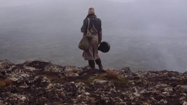 Man i Greatcoat står i dimmiga och steniga landskap — Stockvideo