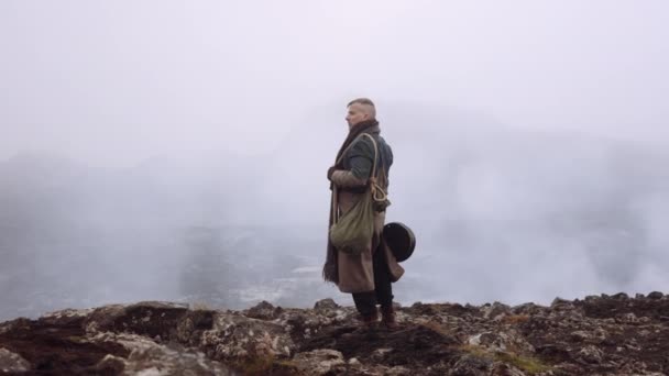 Man In Greatcoat Standing In Misty And Rocky Landscape — Stock Video